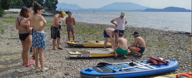 Gruppo di persone con Sup in spiaggia al lago Maggiore