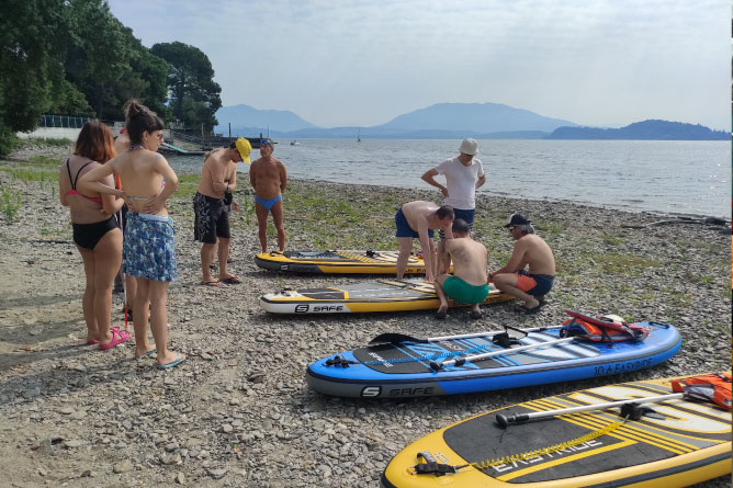 Gruppo di persone con Sup in spiaggia al lago Maggiore